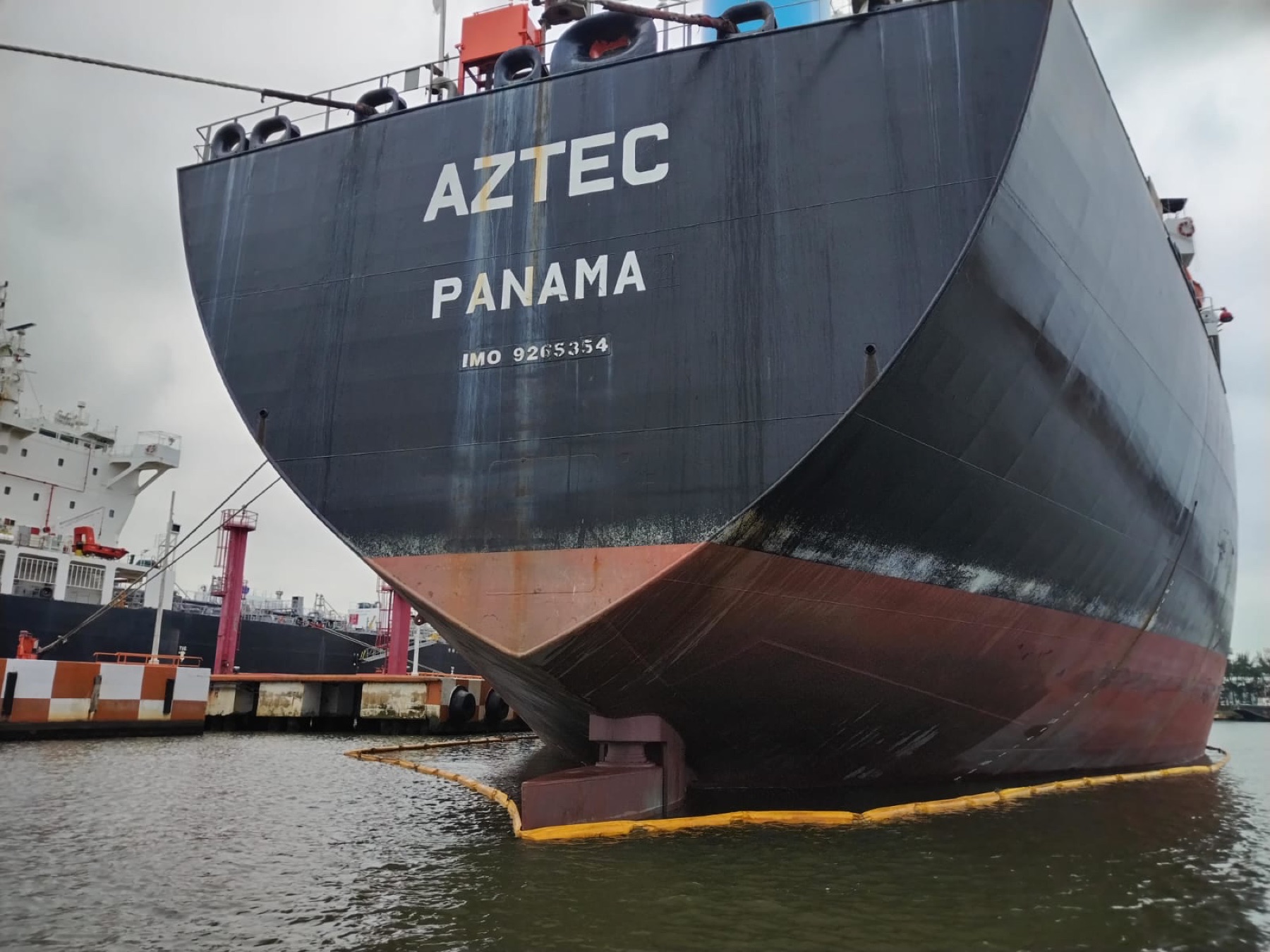 Barrera de contención de hidrocarburos GMM alrededor del casco de un buque en puerto